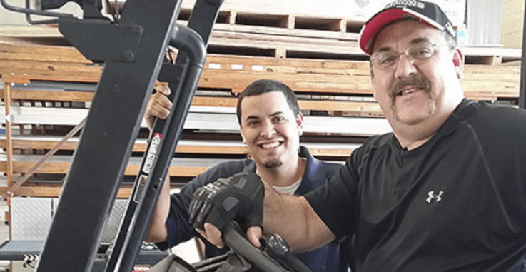 Two male Aluma employees smiling during work
