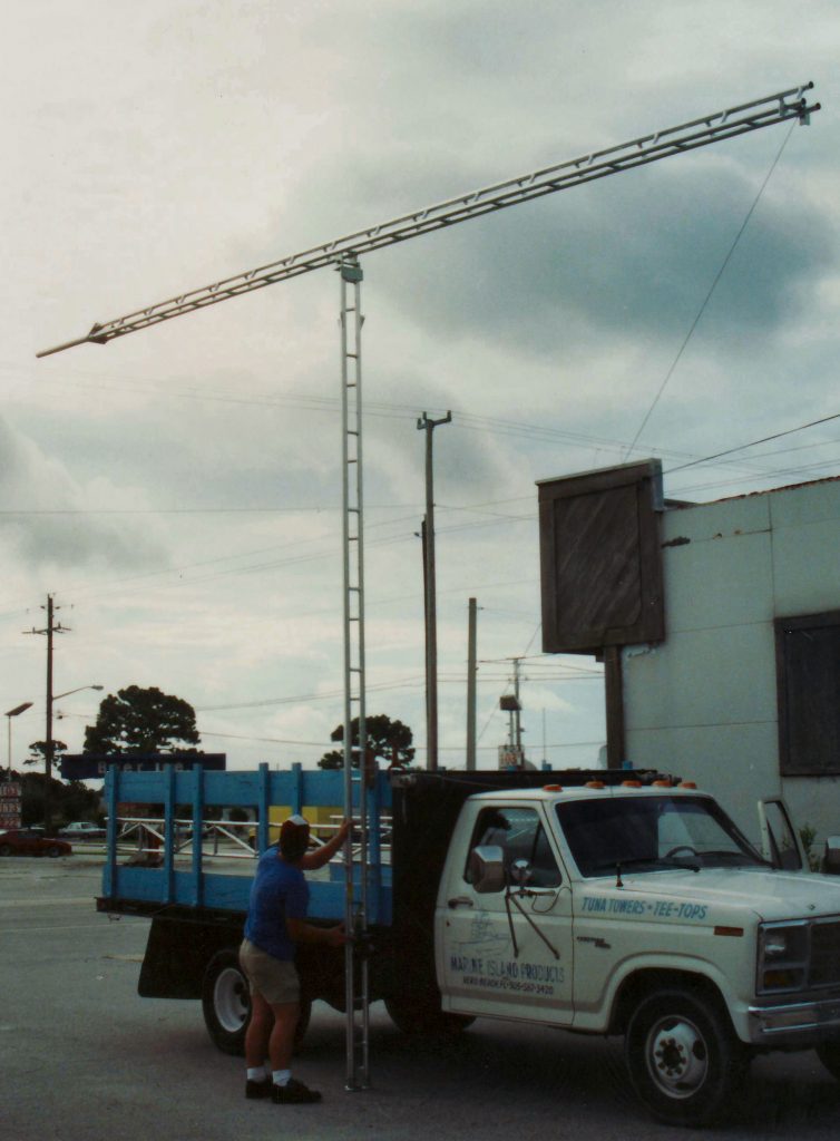 Man attaching an aluminum Aluma tower to a white truck 